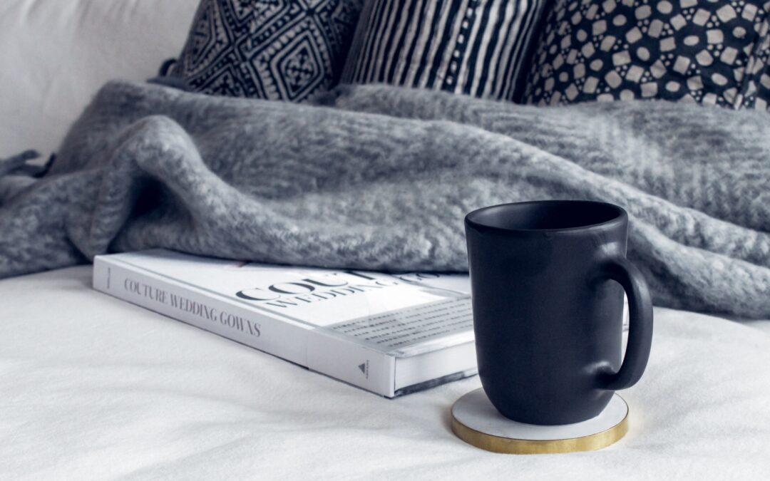 Black coffee mug with a cozy blanket and pillow