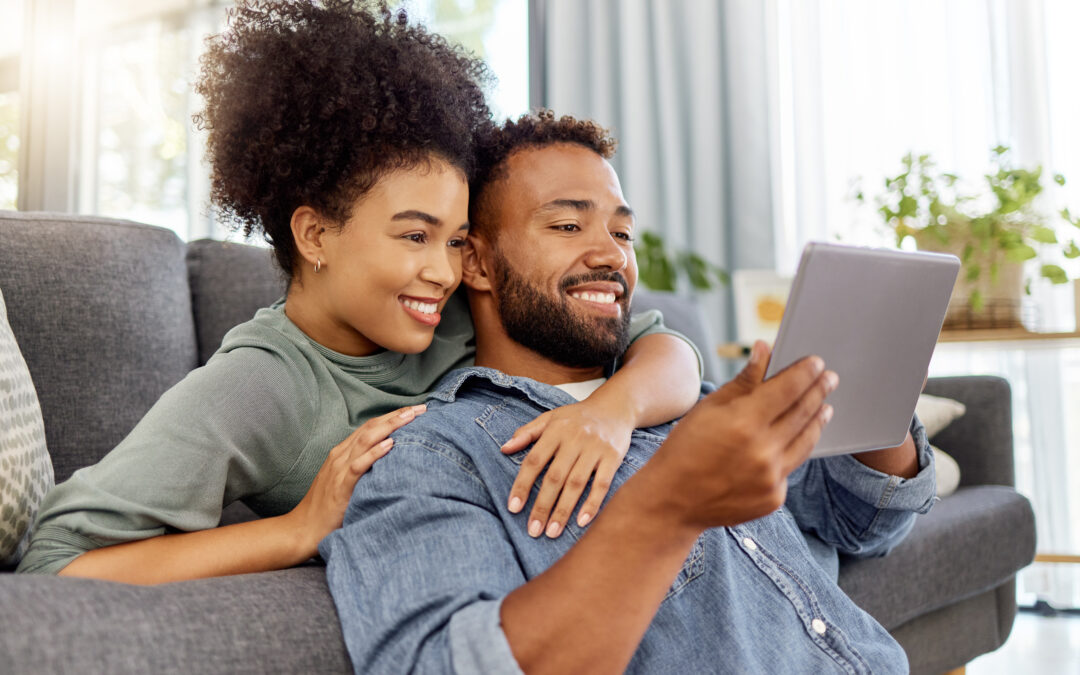 Couple smiling while looking at an ipad